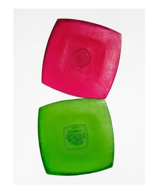 Elevated studio shot of a pink and green square soaps stacked on a white background, showcasing beauty and skincare product photography.