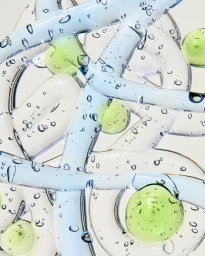 Macro view of transparent gel textures and suspended air bubbles with light green droplets on an off-white background