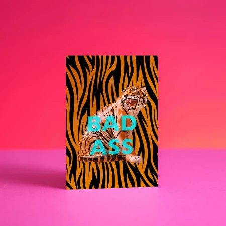 Tiger illustration with animal print on a card in a vibrant pink studio with smooth lighting and bold color contrast.
