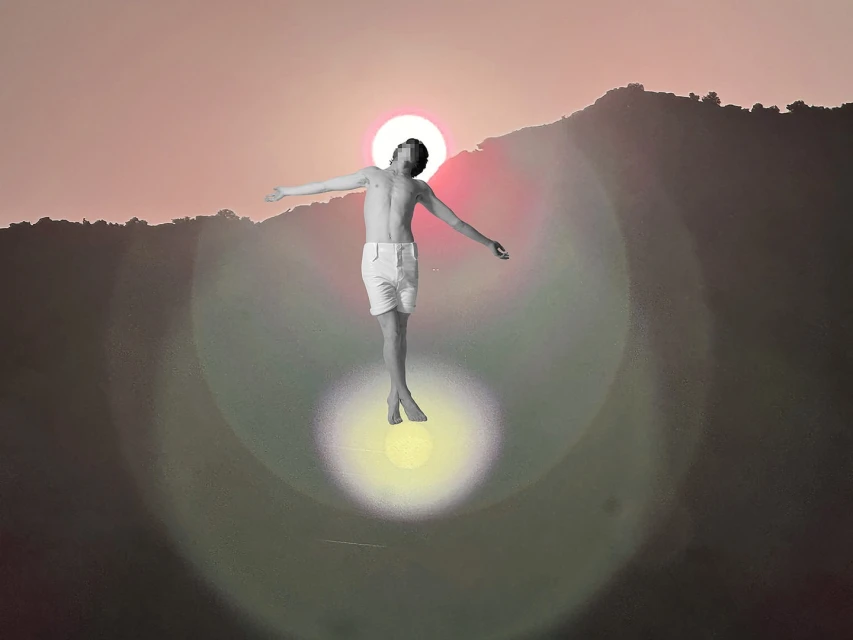 A shirtless young adult with outstretched arms appears to float against a backdrop of hills and a sunset-like sky with lens flare.