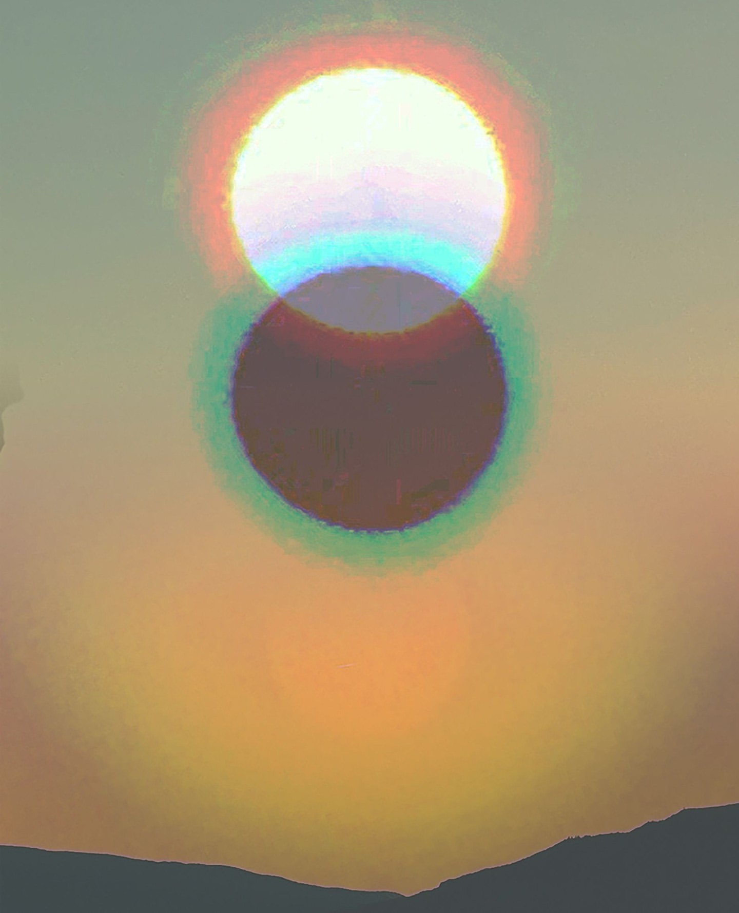 Sun with ethereal aura over a dark mountain silhouette during sunset, creating a serene and abstract nature landscape.