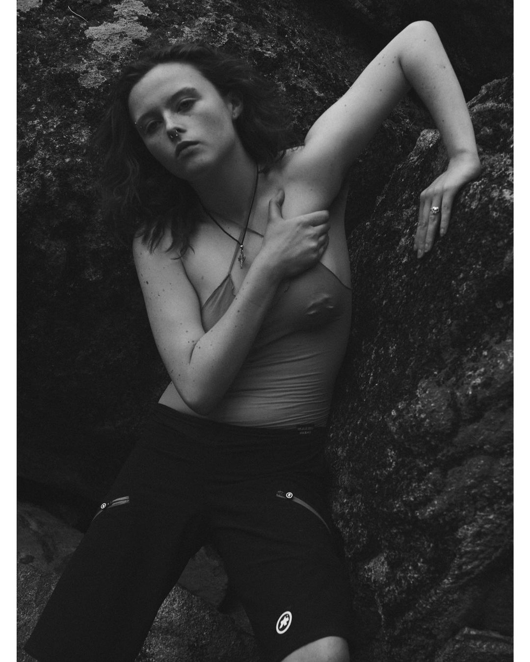 Model leaning against dark rocky terrain wearing a halter top and shorts, photographed by David Sims in New York.