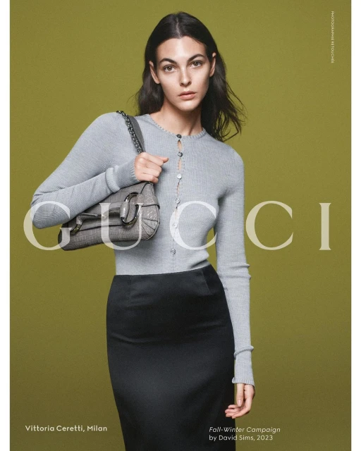 Fashion editorial featuring a woman in a grey cardigan, black skirt, and a Gucci handbag, set against a soft green backdrop.