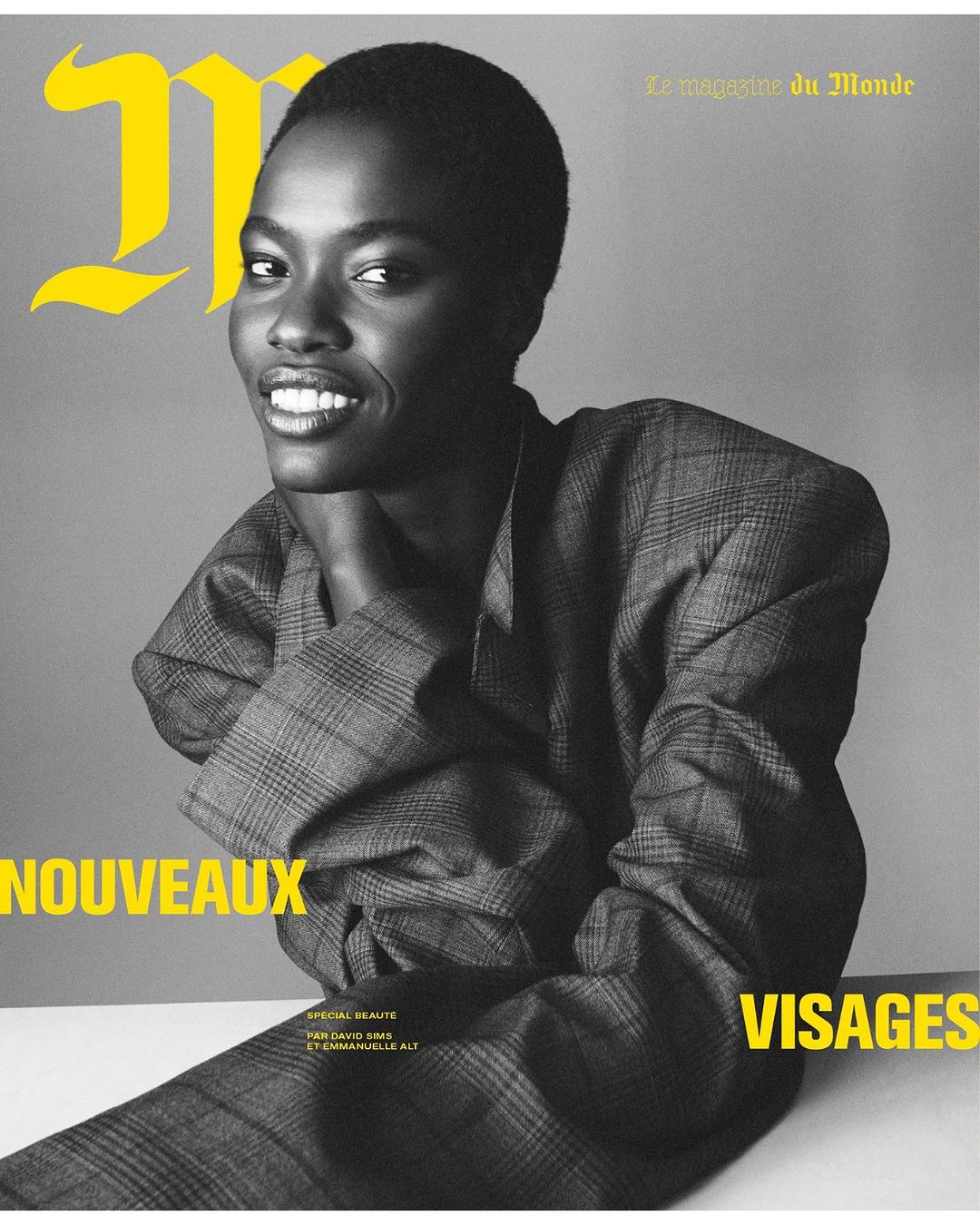 Magazine cover featuring a smiling Black woman wearing a grey plaid blazer against a grey background with yellow text accents.