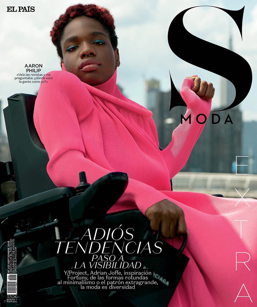 Magazine cover featuring a non-binary person in a pink dress, seated in a wheelchair against a city backdrop, promoting inclusivity and fashion.