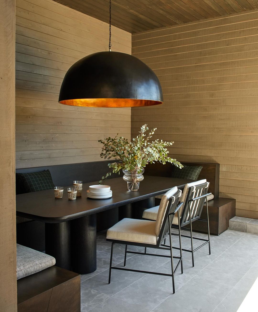 Contemporary dining area featuring a black dome pendant light, dark wood table, and modern chairs, creating an elegant and inviting space.