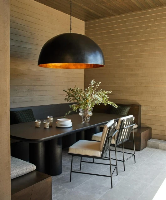Contemporary dining area featuring a black dome pendant light, dark wood table, and modern chairs, creating an elegant and inviting space.