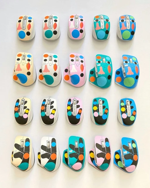 A grid of twenty colorful computer mice, each uniquely decorated with circles and organic shapes, arranged on a clean, white surface.