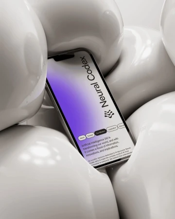 Close-up studio shot of a smartphone displaying 'Neural Codex' website, nestled among abstract, white, glossy, spherical objects.