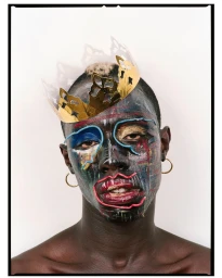 Portrait of a Black man with painted face wearing a gold crown and hoop earrings against a white background