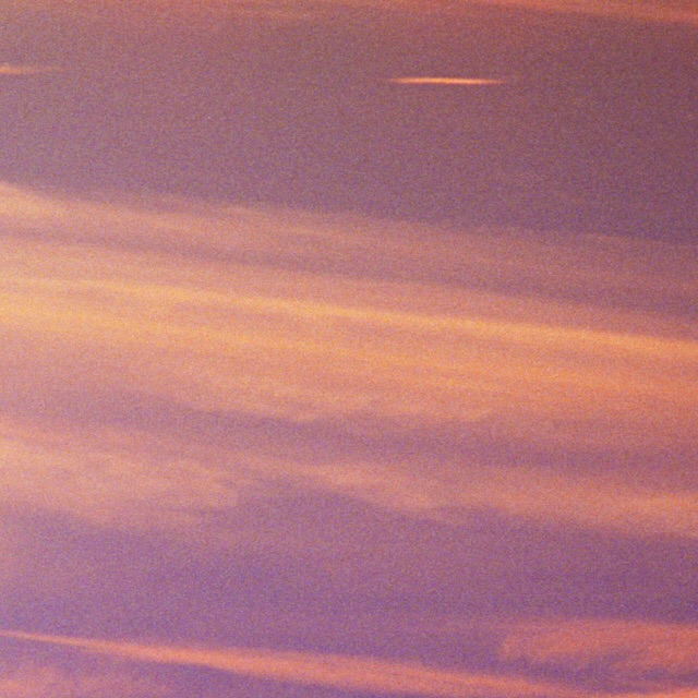 Dramatic pink-tinged sky with soft clouds in horizontal bands, creating a serene and visually captivating skyscape.