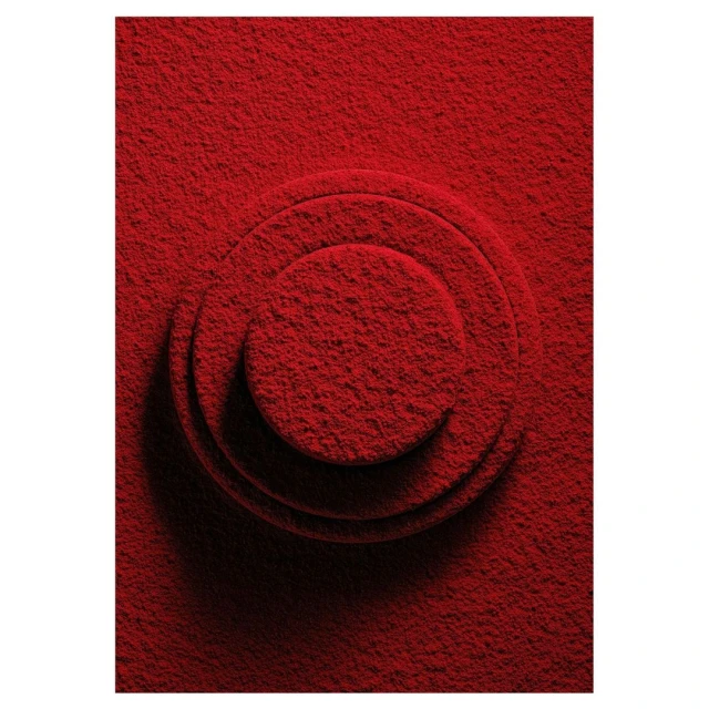 Abstract red background with raised circular pattern. Monochromatic textured surface with concentric ring design and subtle shadows.