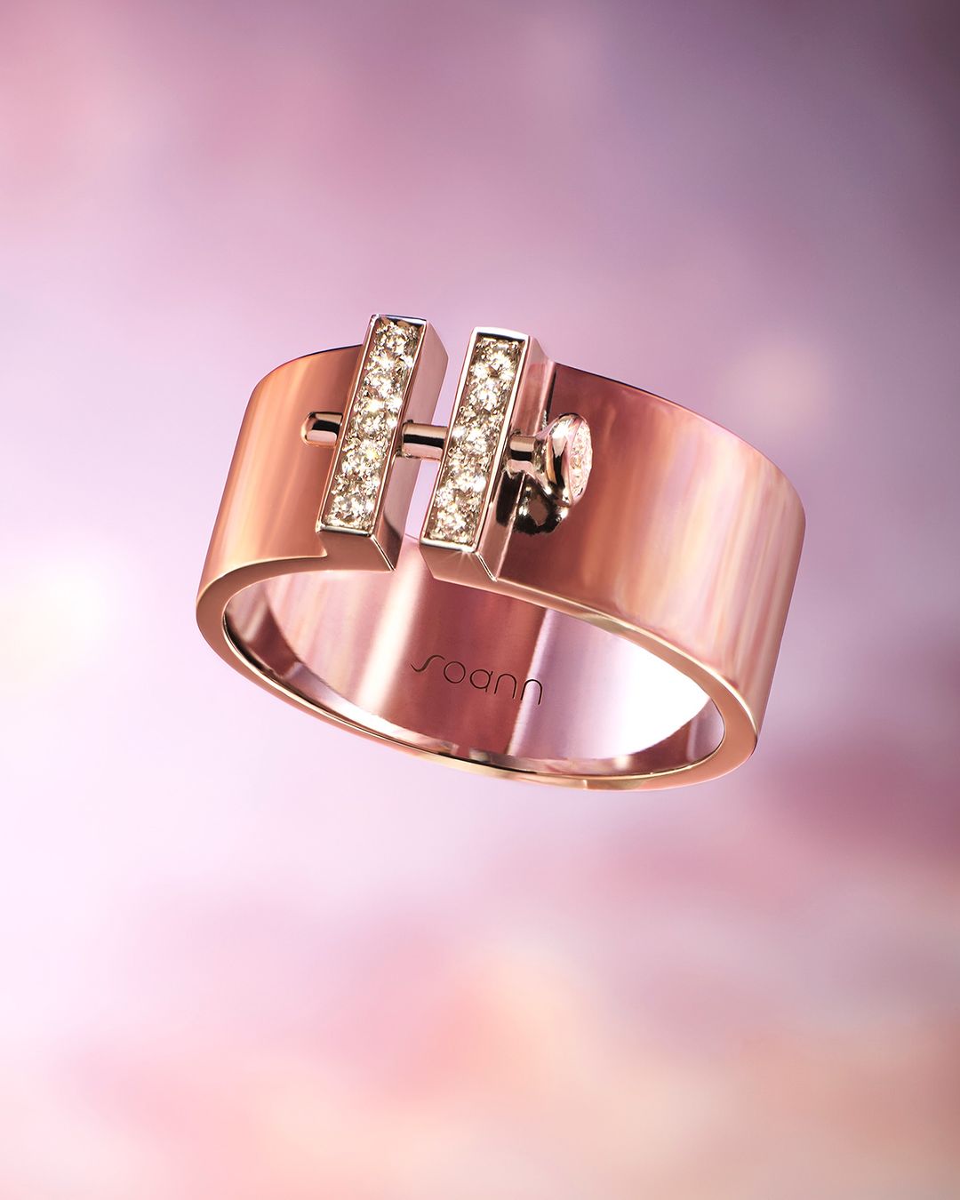 Close-up product shot of a rose gold ring with a bar design adorned with small gems, isolated against a soft pink-purple gradient background.