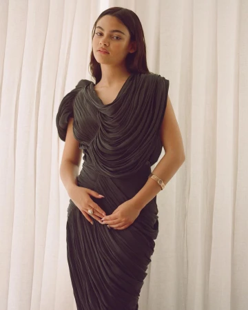 Woman in a dark pleated dress posing against white sheer curtains photographed by Davis Bates.