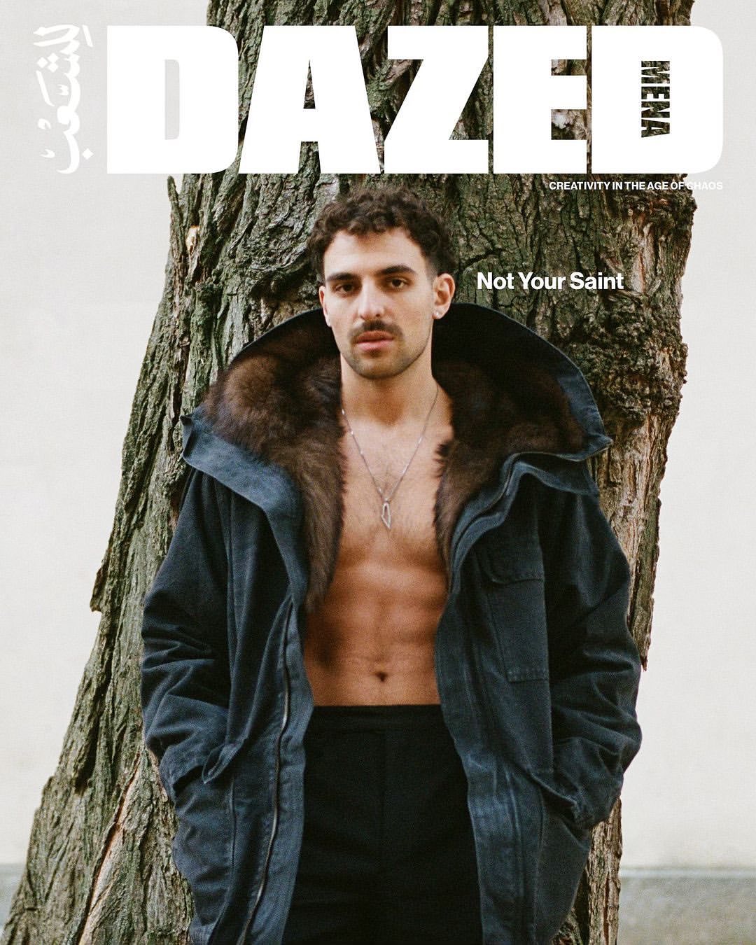 Dazed magazine cover featuring a male model with a fur-lined coat standing next to a tree in a medium shot.