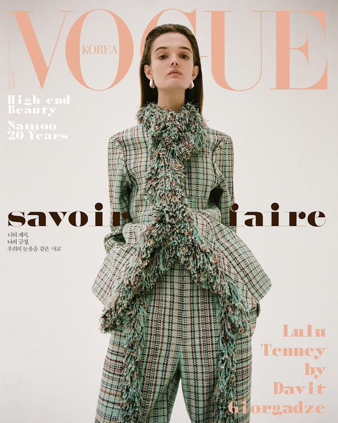 Vogue Korea cover featuring a fashion model in a plaid pantsuit with fringed trim, posing against a clean white backdrop with brand text.