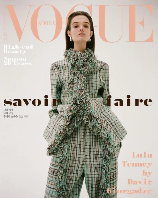 Vogue Korea cover featuring a fashion model in a plaid pantsuit with fringed trim, posing against a clean white backdrop with brand text.