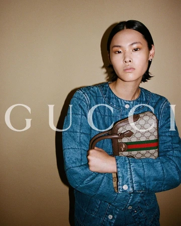 Model in quilted denim jacket holding monogram handbag by Davit Giorgadze