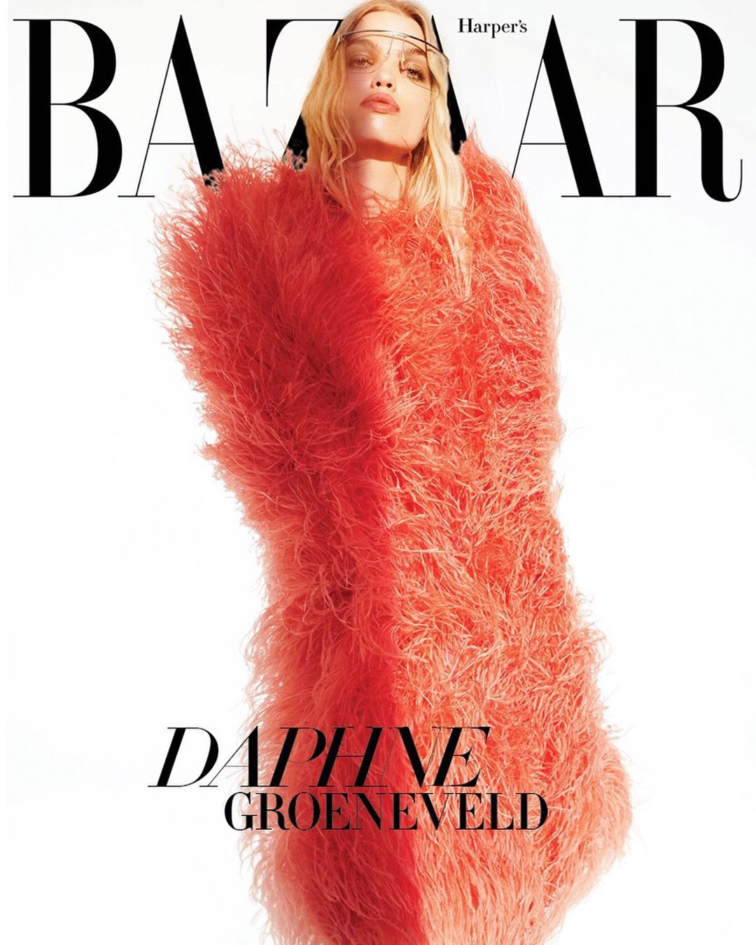 Fashion magazine cover featuring a woman in a striking coral textured garment against a bright white backdrop, emphasizing a bold editorial style.