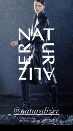 Model in a black leather trench coat and boots standing in the rain, photographed by Daymion Mardel.