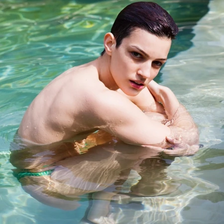 Short-haired woman submerged in clear outdoor swimming pool water photographed by Dean Freeman