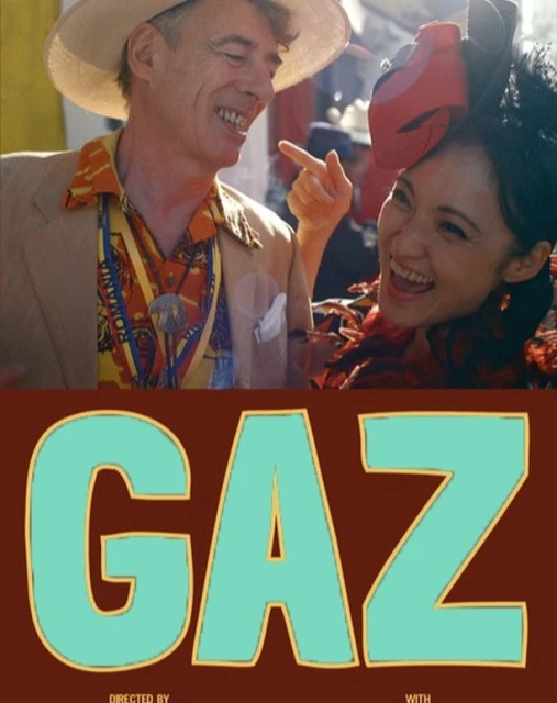 Movie poster featuring a man in a hat pointing and a smiling woman, with 'GAZ' text displayed prominently in teal with a brown outline.