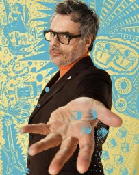 Middle-aged man wearing thick black glasses and dark blazer extending hand toward camera against illustrated yellow background