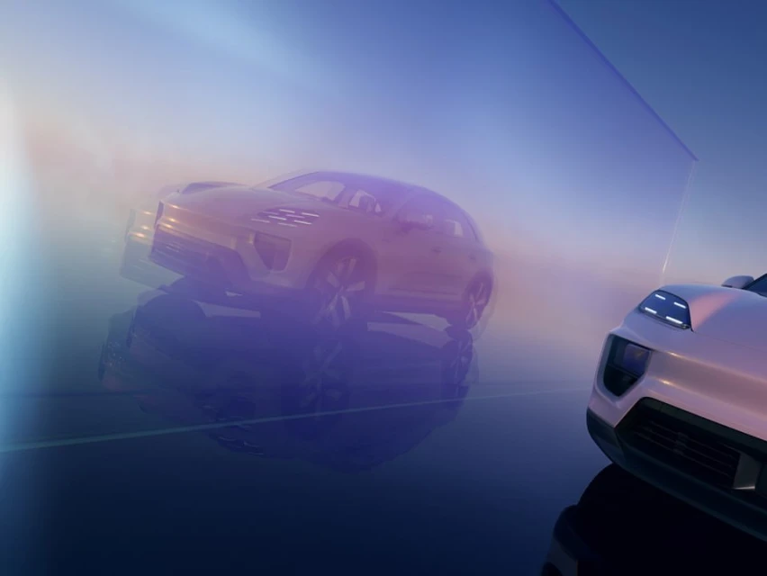 Low-angle shot of two modern SUVs, one in focus and the other reflected in a pane of glass, set against a gradient blue and golden sky.