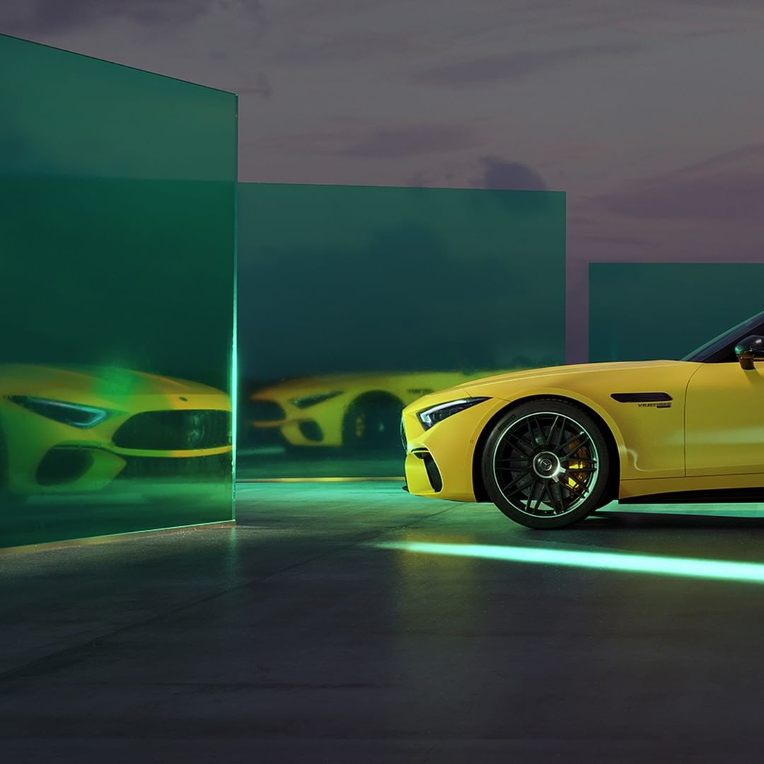 Two yellow Mercedes-AMG cars are displayed in an automotive studio with a creative lighting design and modern aesthetic.