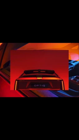 Automotive photography showcases the rear of a futuristic red car with 'OPTIQ' emblem under warm studio lighting. Modern design aesthetic.