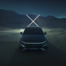 Front view of a dark luxury electric car parked in a desert landscape under a starry night sky with glowing light sticks mounted on the roof.