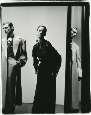 Fashion shot featuring two men in suits and an adult woman in an evening gown, captured in a high-fashion studio setting with neutral backdrop.