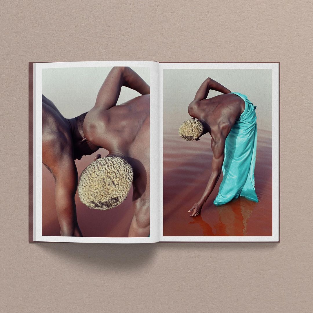 Open book featuring two images: dark-skinned person waist-deep in rose water wearing turquoise cloth and an image of a dark-skinned person.