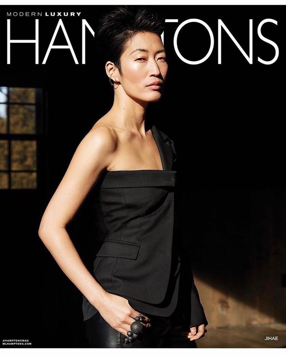 Magazine cover featuring an Asian woman with short hair wearing a black, one-shoulder top, looking off-camera against a dark background.