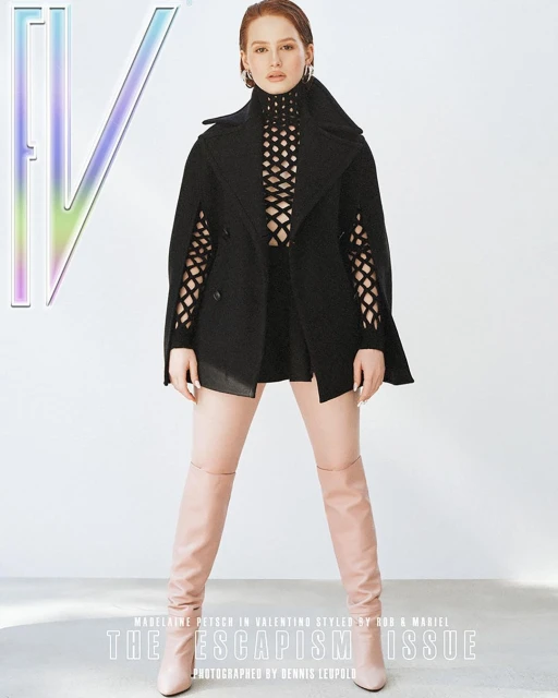 Fashion magazine cover featuring a woman in a black top, black cape jacket, and high boots against a white background.