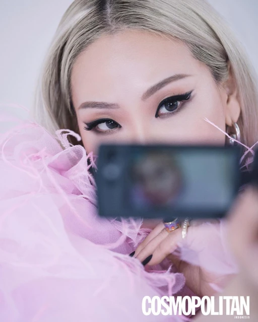 Cosmopolitan Indonesia cover featuring an Asian woman with blonde hair and glamorous makeup holding a phone, indoor studio setting.