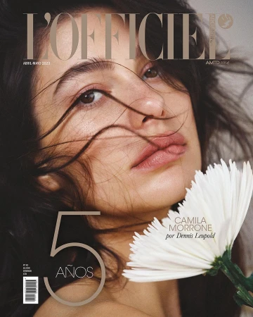Close-up portrait of Camila Morrone holding a white flower against her face, photographed by Dennis Leupold.