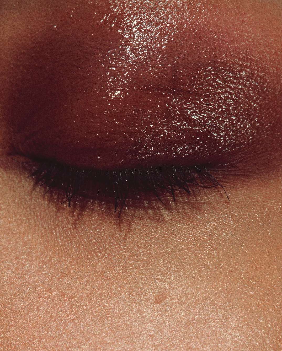Close-up shot of a person's eye with brown eyeshadow and visible eyelashes, highlighting beauty and cosmetic trends.