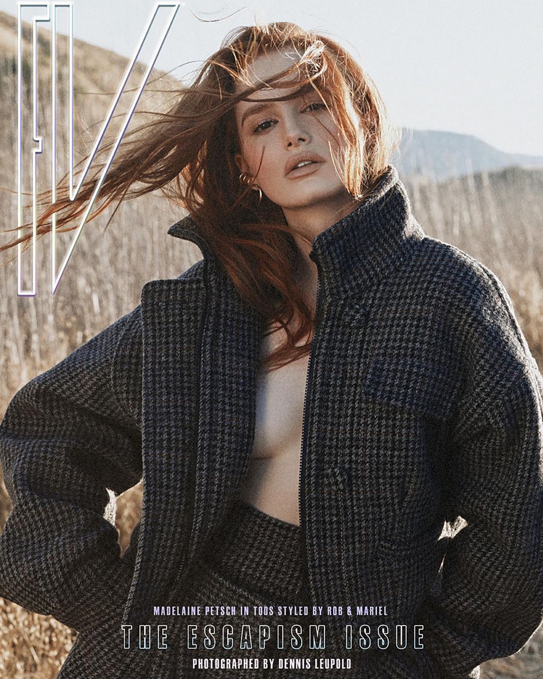 Madelaine Petsch on magazine cover, wearing a houndstooth jacket, with windblown red hair, set against a field and mountain backdrop.