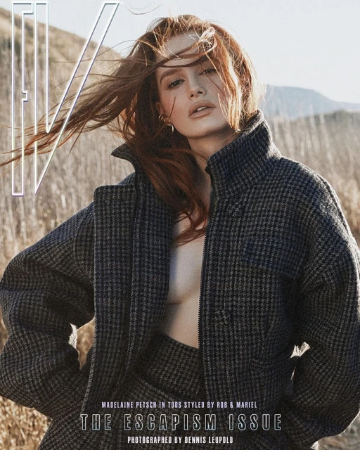 Madelaine Petsch on magazine cover, wearing a houndstooth jacket, with windblown red hair, set against a field and mountain backdrop.