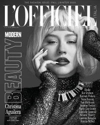 Close-up monochrome magazine cover featuring Christina Aguilera in a sparkly high-neck top and blonde wig.