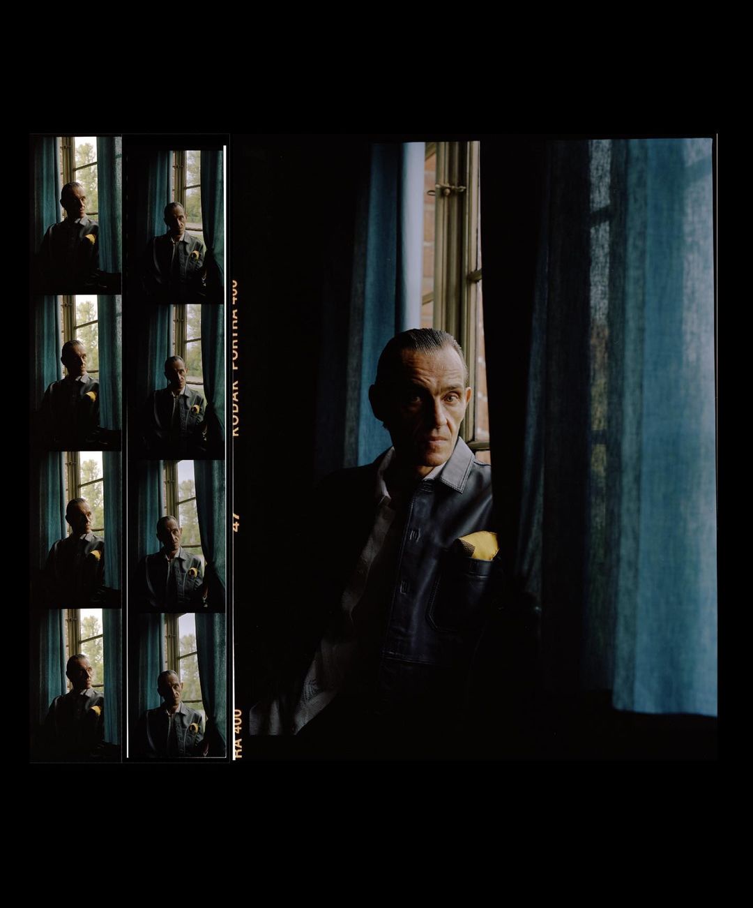 Mature man gazes out window with blue curtains; adjacent strip of image frames shows similar poses in a darkly lit room.