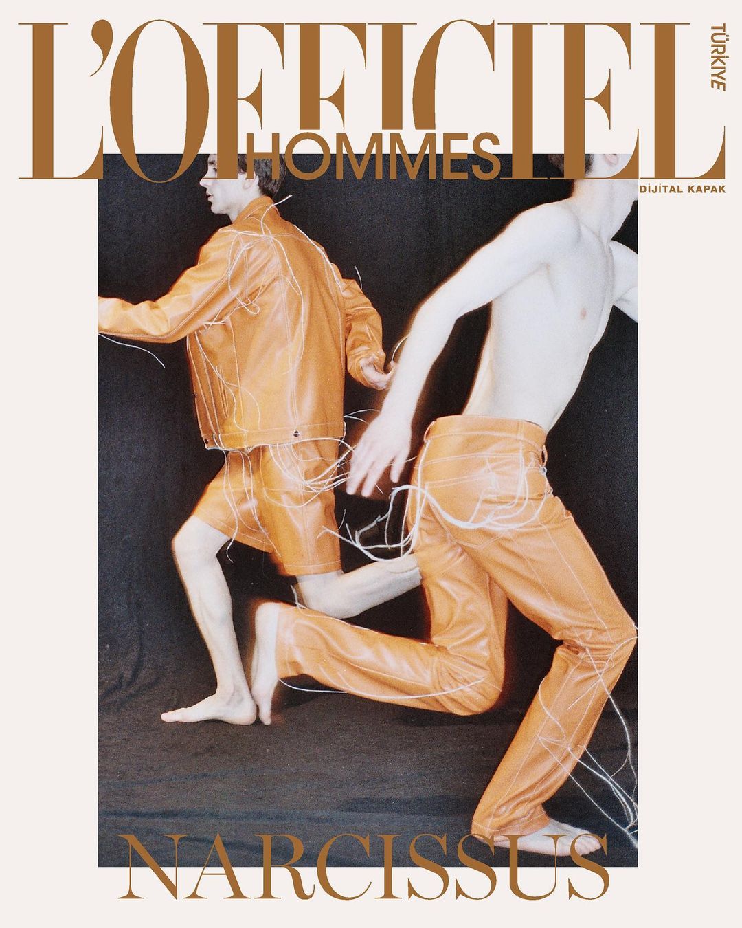 Two men in orange outfits strike dynamic poses on a fashion magazine cover, with 'L'Officiel Hommes' and 'Narcissus' text overlays.