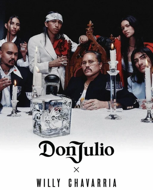 Group of adults gathered around a table with a Don Julio tequila bottle and candles, shot in a dimly lit indoor setting.