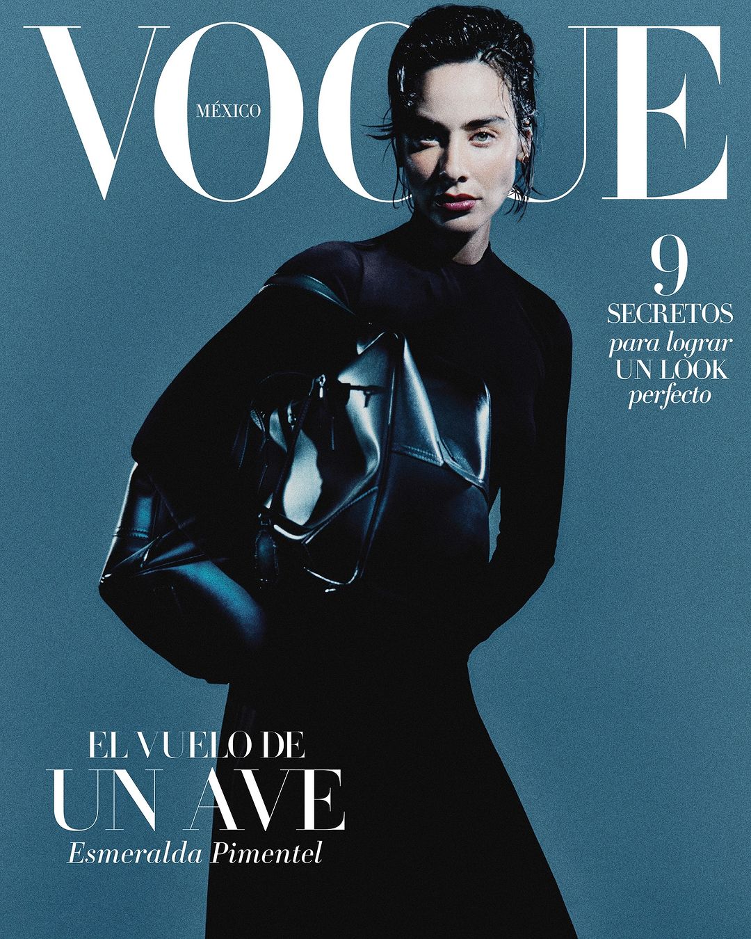 Magazine cover featuring Esmeralda Pimentel with wet hair wearing a black top and holding a dark handbag against a blue background.