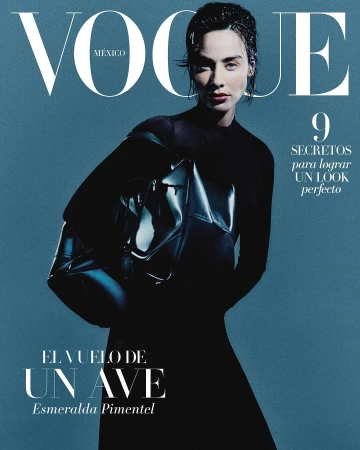Magazine cover featuring Esmeralda Pimentel with wet hair wearing a black top and holding a dark handbag against a blue background.