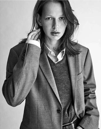 Portrait of a model wearing a grey blazer, V-neck sweater, and collared shirt by photographer Diego Merino