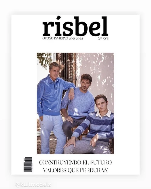 Three adult males pose on a magazine cover in soft, casual sweaters with a backdrop of trees and shadows, presented in a vertical shot.