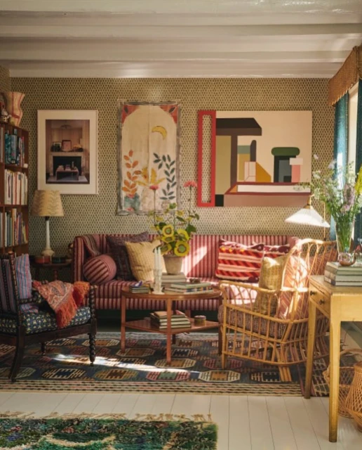 Eclectic living room featuring a striped sofa, patterned chairs, colorful rug, and artwork, creating a cozy and artistic interior design.