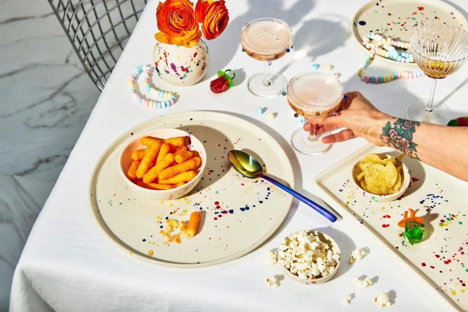 Overhead view of a table set with snacks, drinks, and colorful decorations, creating a festive and inviting atmosphere for a celebration.